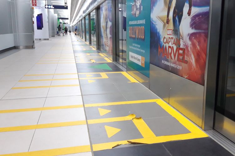 Stiker line antrean pintu masuk MRT Jakarta Stasiun Bundaran HI yang sudah mulai rusak, Rabu (17/4/2019)