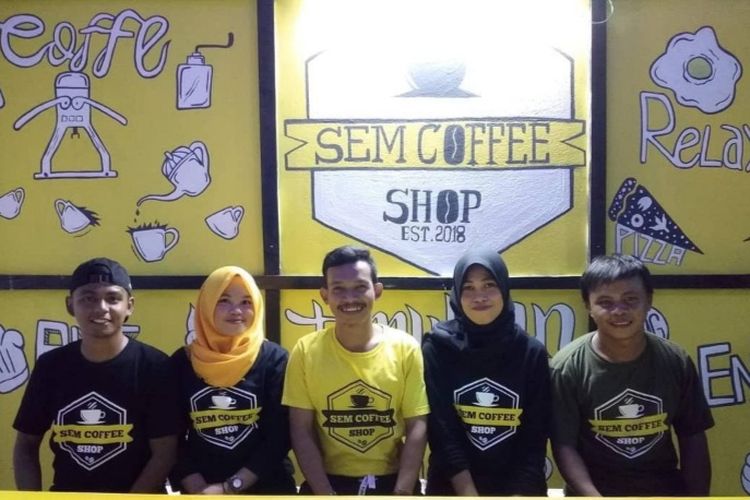 Sem baju kuning duduk dengan karyawannya di