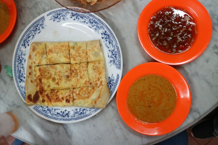 Roti prata isi daging yang mirip dengan martabak telur dicocol dengan kuah kari dan kuah sejenis acar yang asam dan menyegarkan