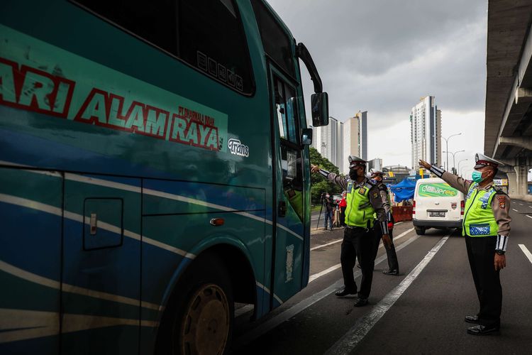 bPolisi menghalau mobil bus yang membawa penumpang di jalan tol Jakarta-Cikampek untuk keluar ke Gerbang tol Cikarang Barat, Kabupaten Bekasi, Jawa Barat, Jumat (24/4/2020). Larangan mudik mulai diberlakukan 24 April 2020 pukul 00.00 WIB. Polda Metro Jaya melarang kendaraan pribadi baik motor atau mobil dan kendaraan umum berpenumpang keluar dari wilayah Jabodetabek. Pemeriksaan dan penyekatan kendaraan tersebut akan dilakukan di 18 titik pos pengamanan terpadu dan pos-pos check point di jalur tikus dan perbatasan.