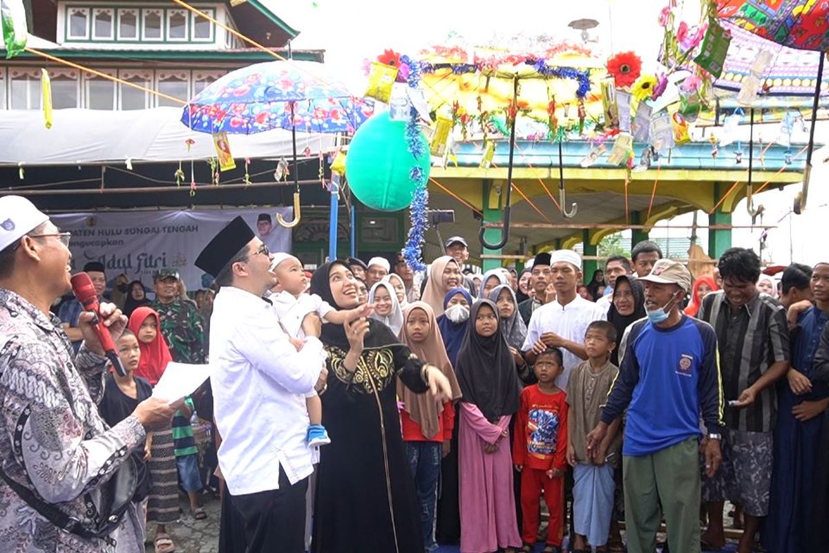 Bupati Hulu Sungai Tengah (HST) H Aulia Oktafiandi didampingi Ketua TP PKK HST Cheri Bayuni Budjang Aulia Oktafiand dengan membawa putranya Andri Sulaiman yang berusia 15 bulan mengikuti tradisi Batumbang Apam di Masjid Al-Munawarrah, Desa Pajukungan, Selasa (25/4/2023).