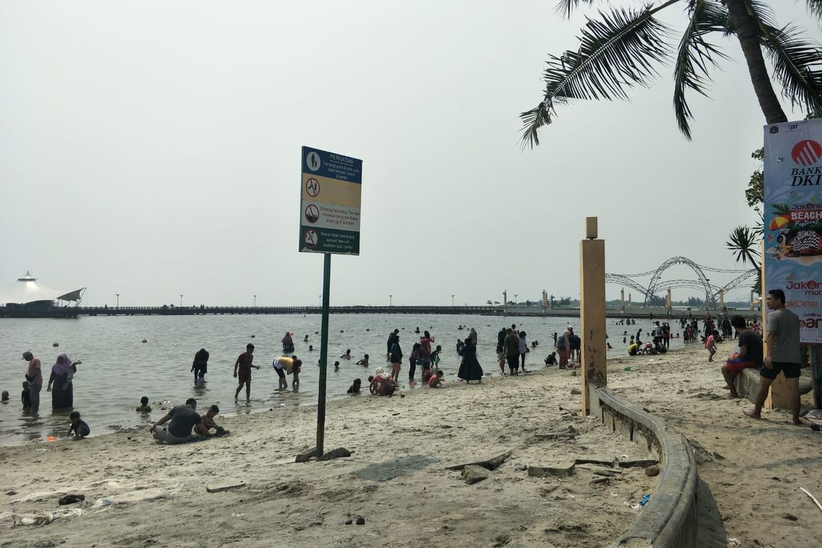 Sejumlah pengunjung memadati area Pantai Ancol pada Minggu (4/6/2023).