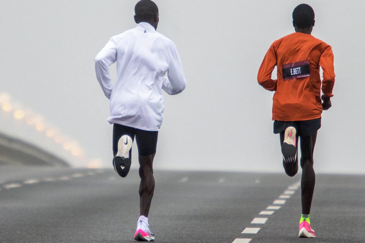 Pelari Kenya Eliud Kipchoge (kiri) melakukan pemanasan di Reichsbrücke sebelum mencoba memecahkan rekor lari marathon di bawah 2 jam pada 12 Oktober 2019 di Vienna,
