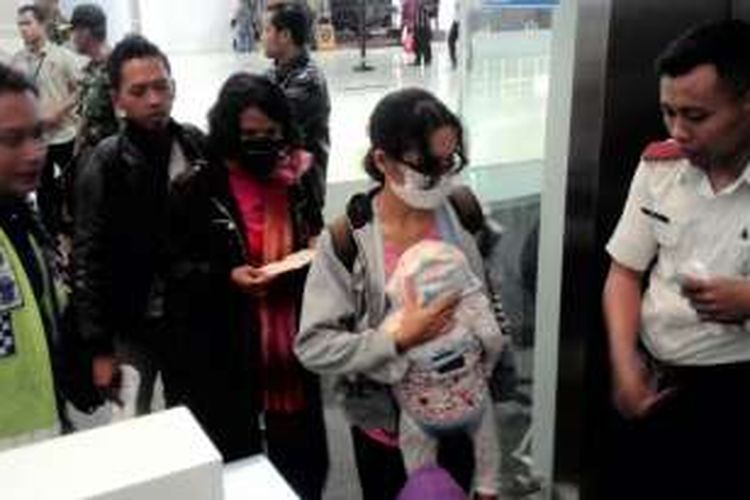 Eks Gafatar melewati pintu masuk ke pesawat di Bandara SAMS Sepinggan diBalikpapan, Kaltim. sejumlah 109 eks Gafatar, terdiri 23 orang menuju Jakarta, 37 orang ke Semarang dan 49 lain ke Makassar. Mereka termasuk 69 dewasa, 29 anak-anak, dan 11 balita.  