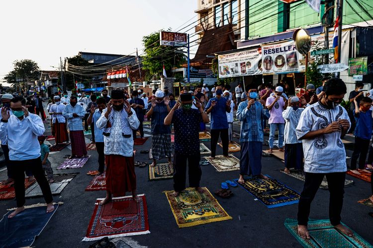 Umat muslim melaksanakan shalat Idul Adha di Jalan Pramuka Raya, Cempaka Putih, Jakarta Timur, Jumat (31/7/2020). Umat muslim menggelar shalat Idul Adha secara berjamaah dengan menerapkan protokol kesehatan seperti jaga jarak serta wajib mengenakan masker guna mencegah penyebaran COVID-19.