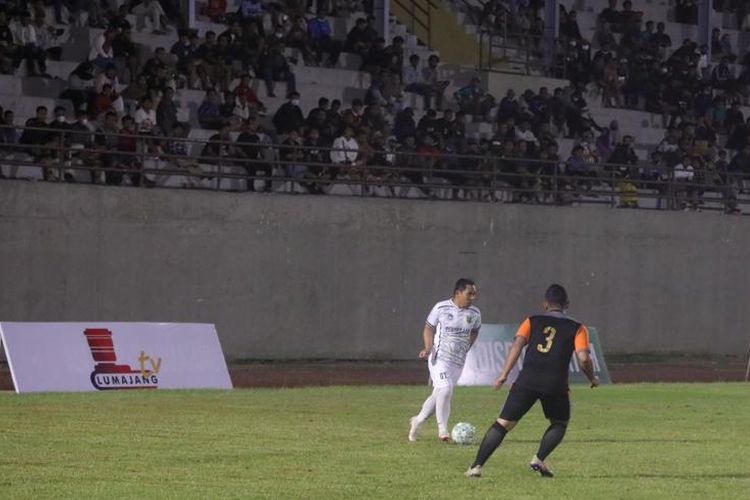 Bupati Lumajang Thoriqul Haq (kostum putih) mencoba melewati penjagaan pemain Mahameru Fc saat Timnas Legend melawan Mahameru FC, Jumat (15/4/2022).