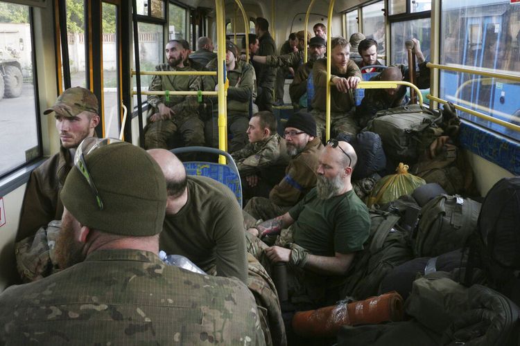 Prajurit Ukraina duduk di dalam bus setelah mereka dievakuasi dari pabrik baja Azovstal Mariupol yang terkepung, dekat sebuah penjara di Olyonivka, di wilayah di bawah pemerintahan Republik Rakyat Donetsk, Ukraina timur, Selasa, 17 Mei 2022.