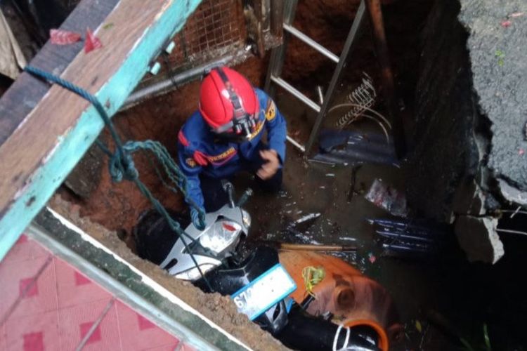 Petugas damkar Jakarta Timur memgevakuasi satu unit motor milik warga yang terperosok lubang tanki septik di Balekambang, Kramat Jati, Jakarta Timur, Selasa (21/7/2020).