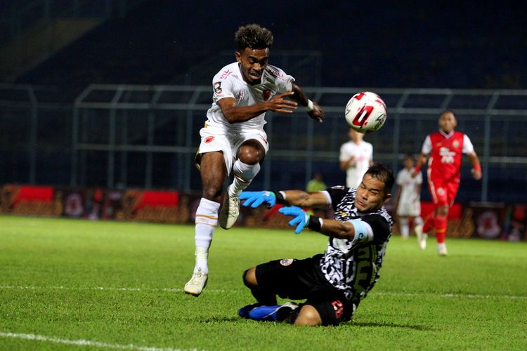 Penjaga gawang Persija Jakarta Andritany Ardhiyaksa menghalau serangan pemain muda PSM Makasaar Yacob Sayuri saat laga perdana babak penyisihan grup B Piala Menpora 2021 yang berakhir dengan skor 0-2 di Stadion Kanjuruhan Kabupaten Malang, Jawa Timur, Senin (22/03/2021) malam.
