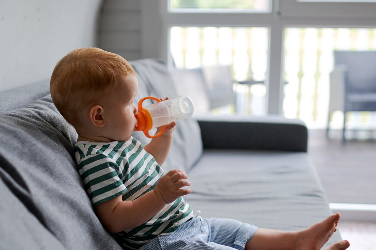 Ilustrasi bayi ngedot atau minum susu dari botol.