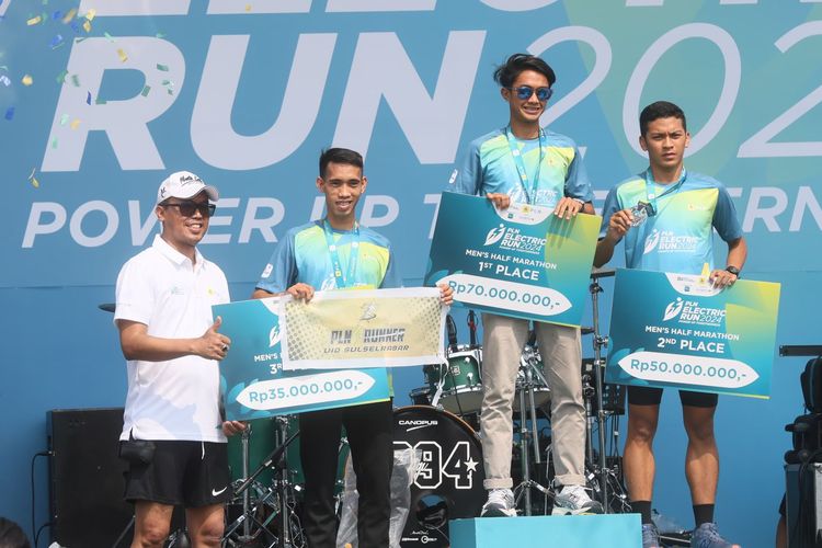 Penyerahan penghargaan untuk pemenang kategori Men?s Half Marathon PLN Electric Run 2024. Keterangan foto: Direktur Transmisi dan Perencanaan Sistem PLN, Evy Haryadi (kiri), juara 1 Men?s Half Marathon, Robi Syianturi (kedua dari kanan), juara 2 Men?s Half Marathon, Rikki (kanan), dan juara 3 Men?s Half Marathon, Syamsuddin Massa (kedua dari kiri).
