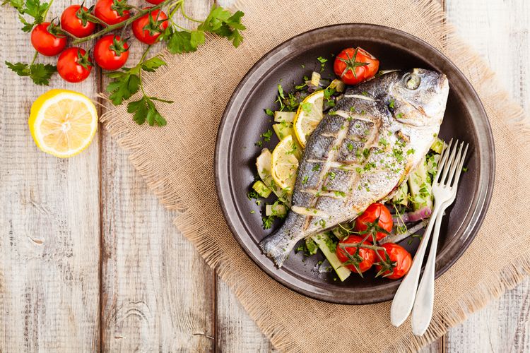 Ilustrasi ikan panggang utuh dalam oven. Cara masak ikan tersehat agar nutrisi tidak hilang.