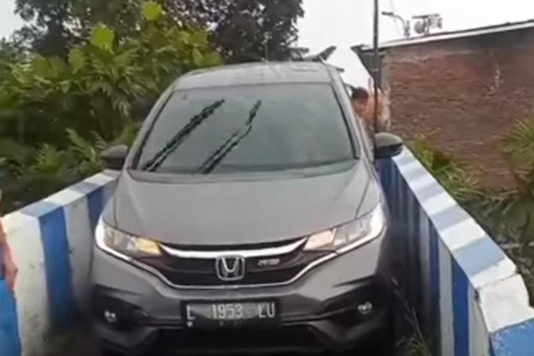 Tangkapan layar dari salah satu media sosial memperlihatkan mobil Honda Jazz RS dengan nomor polisi L 1953 LU berwarna silver metalik terjebak di jembatan kecil mengarah ke Jembatan Pelor, Kota Malang, Jawa Timur. 