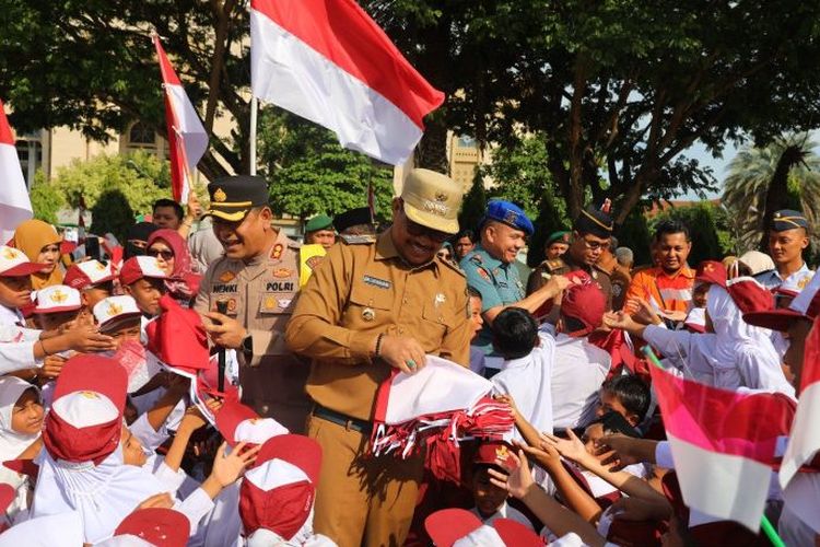 Pj Wali Kota Lhokeumawe A Hanan saat membagikan bendera merah putih kepada siswa di wilayah Kota Lhokseumwe usai peluncuran gerakan pembagian 10 juta bendera merah putih di Lapangan Hiraq, Lhokseumawe, Aceh, Senin (10/6/2024). 