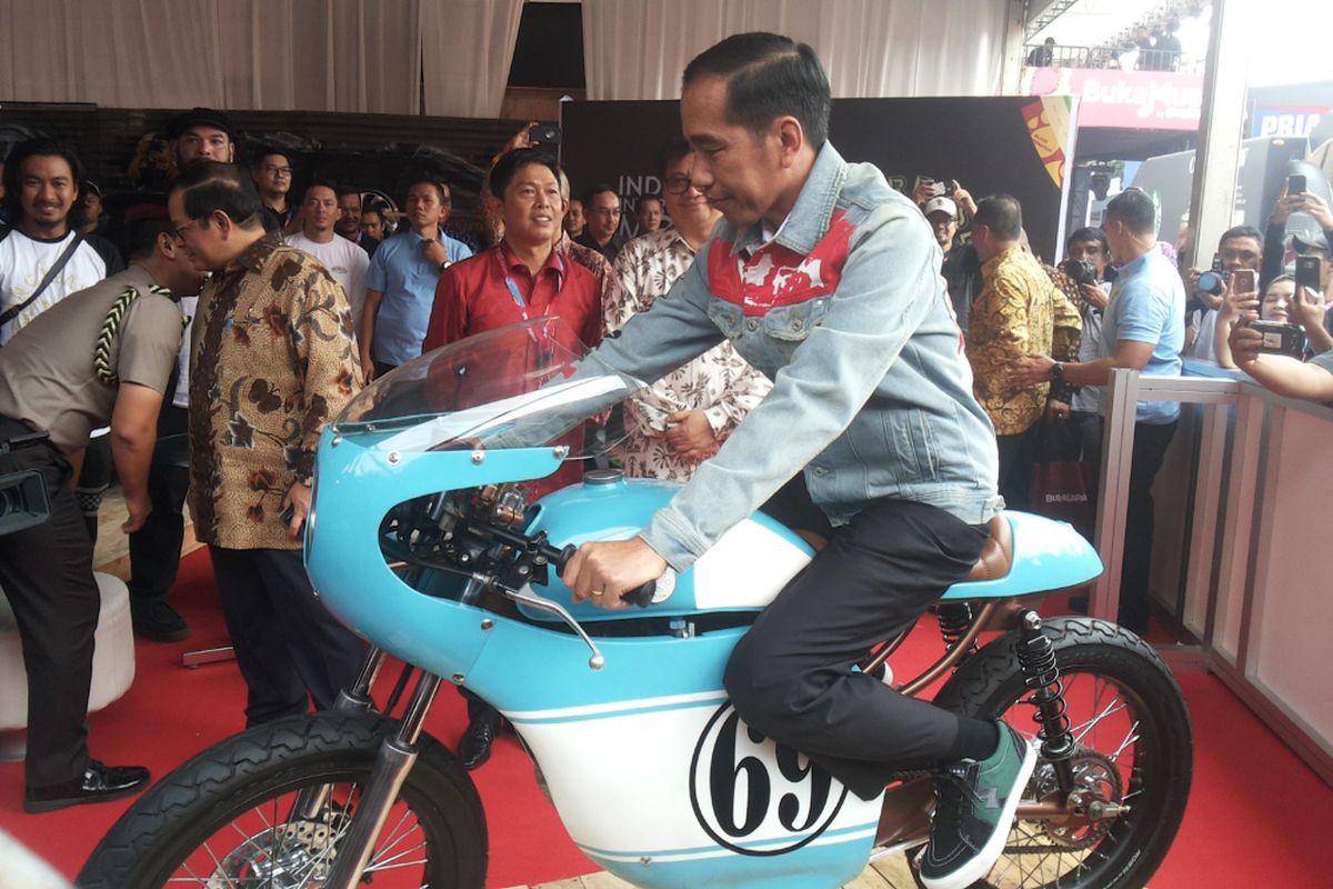 Presiden Joko Widodo menaiki salah satu sepeda motor Honda CB 125 lawas yang dipamerkan di stan Increase saat berlangsungnya hari pertama pameran Indonesia International Motor Show (IIMS) 2018, di JIExpo Kemayoran, Jakarta, Kamis (19/4/2018). Motor yang dimodifikasi bergaya caferacer merupakan milik putra sulung Jokowi, Gibran Rakabuming.