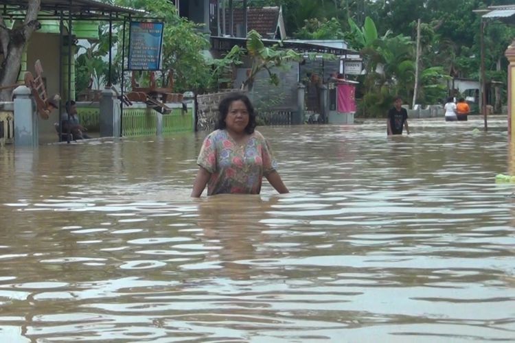 Warga berada di tengah banjir yang masih menggenang, di Desa Kranding Kecamatan Pogalan Jawa Timur (07/03/2019)