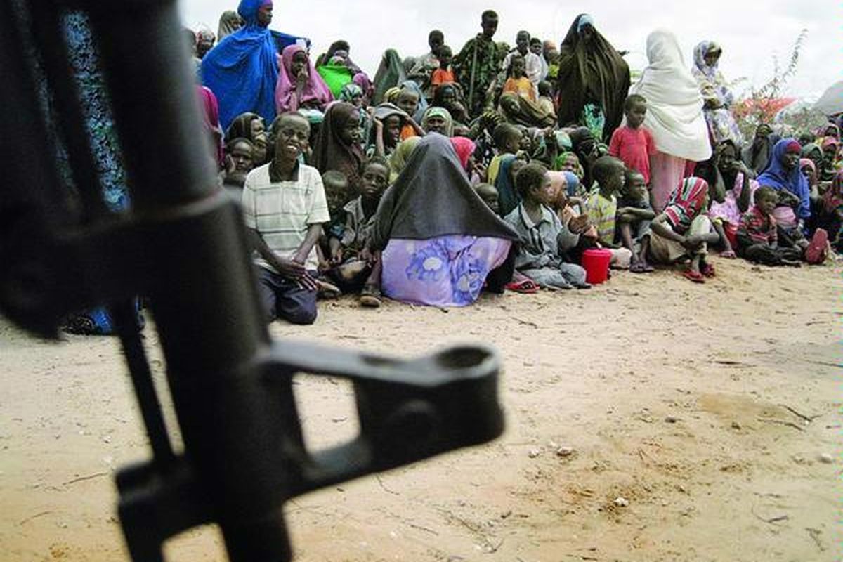 Pengungsi Somalia menunggu pembagian bantuan makanan di sebuah kamp di selatan Mogadishu, Kamis (21/7). Pejabat pemerintah mengatakan, kamp itu menerima 650 pengungsi baru setiap hari.