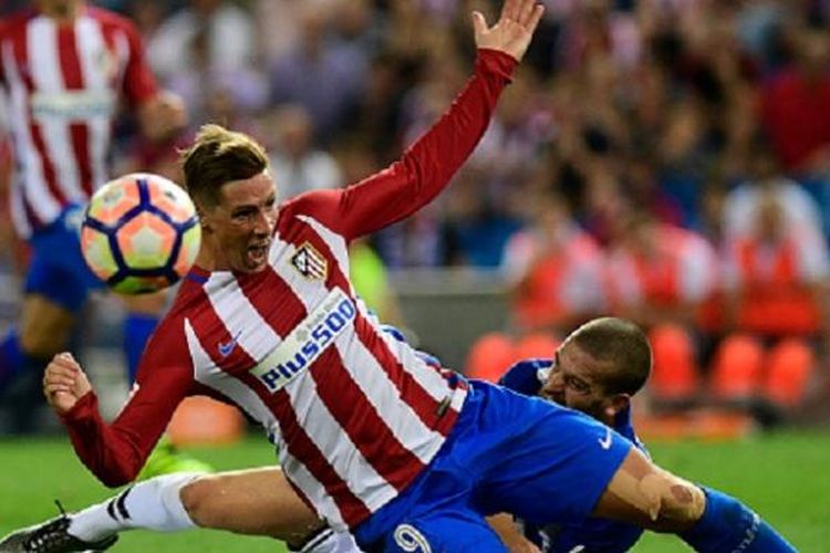 Striker Atletico Madrid, Fernando Torres, dijatuhkan pemain Alaves, Viktor Laguardia, saat kedua tim beradu di Vicente Calderon, Minggu (21/8/2016). 