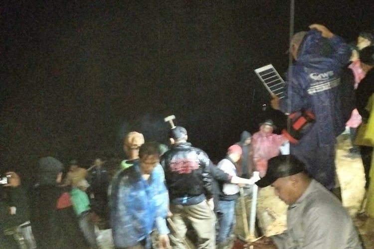 Warga dan aparat pemerintah, TNI/Polri berusaha melakukan pembersihan material longsoran di Kampumg Sirnagalih, Desa Talagajaya, Kamis (26/04/2024) malam