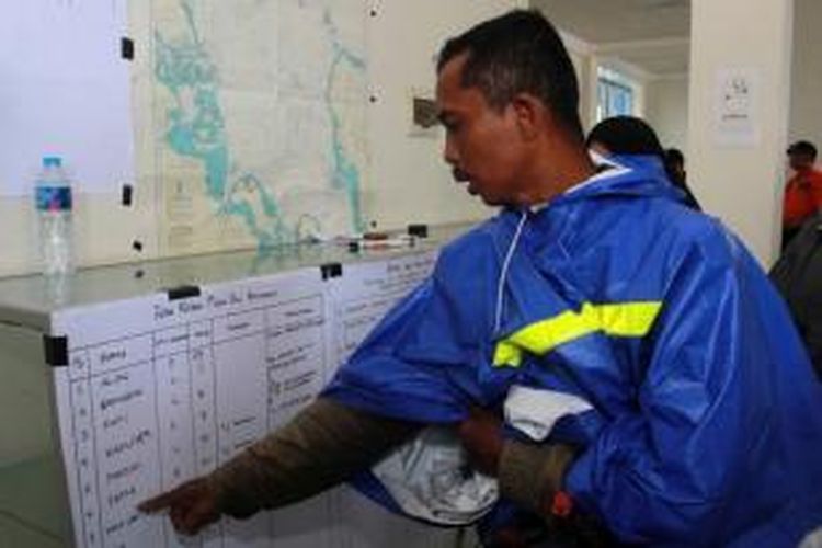 Seorang warga mencari nama keluarga dalam daftar korban yang dinyatakan hilang oleh Basarnas di Posko SAR Pelabuhan Rasau Jaya, Kabupaten Kubu Raya, Kalimantan Barat, Senin (14/12/2015).