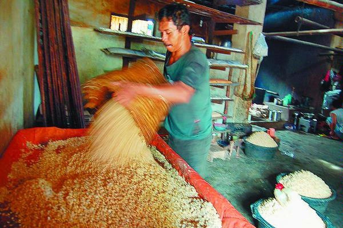 Bejo, perajin tempe di Gunung Sulah, Sukarame, Bandar Lampung, mencampur biji kedelai yang sudah direbus untuk segera diberi ragi di tempat usaha miliknya, Sabtu (1/3). Sudah hampir empat hari ini perajin tahu dan tempe kembali mengeluhkan kenaikan harga kedelai.  