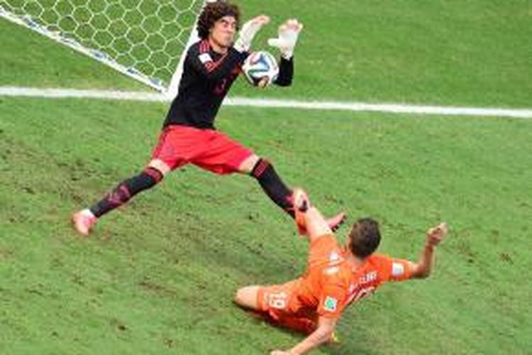 Kiper tim nasional Meksiko, Guillermo Ochoa, menepis bola tembakan bomber Belanda, Klaas Jan-Huntelaar, pada pertandingan perempat final Piala Dunia, Minggu (30/6/2014). 