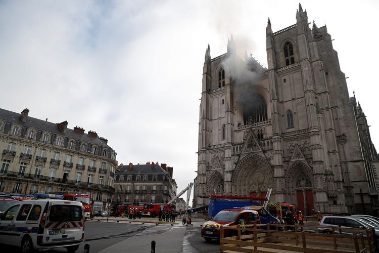Pemadam kebakaran Perancis berjibaku memadamkan api di Katedral St Pierre dan St Paul. Bangunan legendaris abad ke-15 di Nantes itu terbakar pada Sabtu (18/7/2020).