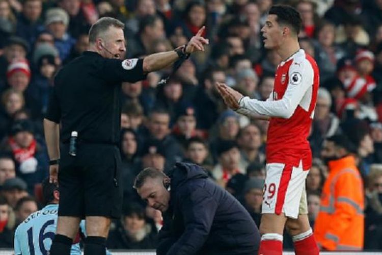 Gelandang Arsenal, Granit Xhaka, diusir wasit Jon Moss seusai melanggar pemain Burnley, Steven Defour, pada laga Premier League di Stadion Emirates, Minggu (22/1/2017). 