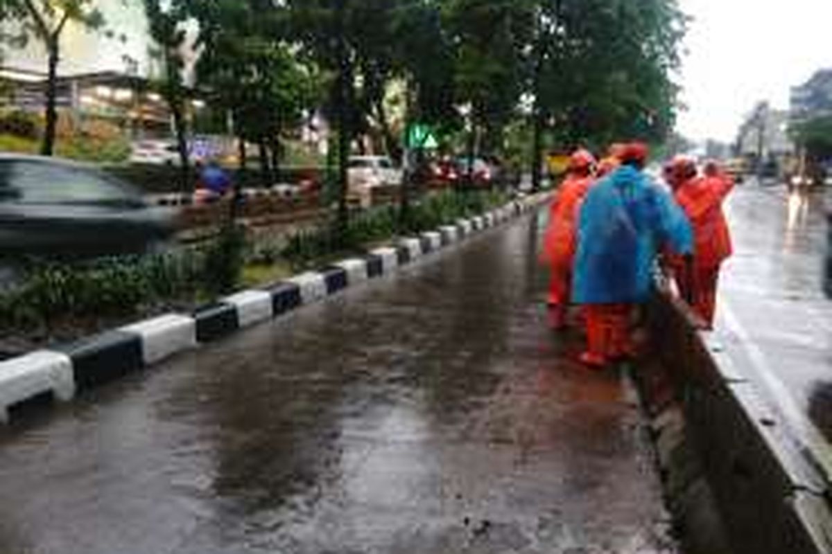 Petugas PPSU Kelurahan Kebayoran Lama Utara terjun di Jalan Sultan Iskandar Muda, tepatnya depan Gandaria City Mal, Jakarta Selatan, yang sempat digenangi banjir. Jumat (11/11/2016).