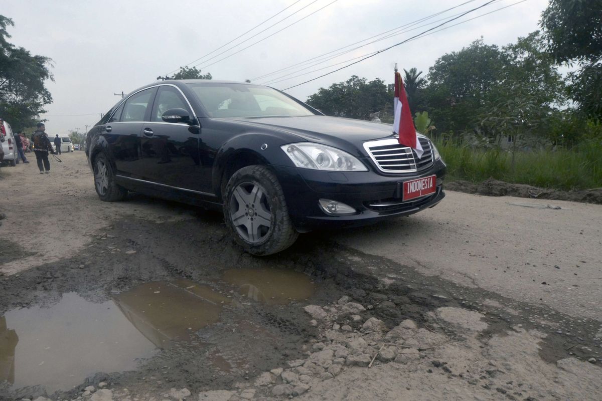 Mobil dinas Presiden Joko Widodo melintas di jalan rusak di Kampung Rama Nirwana, Seputih Raman, Lampung Tengah, Lampung, Jumat (5/5/2023). Presiden Jokowi mengucurkan dana Rp 800 miliar untuk memperbaiki jalan rusak di Provinsi Lampung.