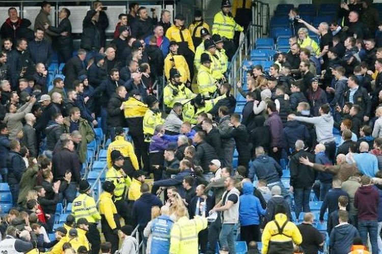 Suporter Manchester City dan pendukung Manchester United tampak bersitegang saat kedua tim melakoni derbi Manchester, Minggu (20/3/2016). 