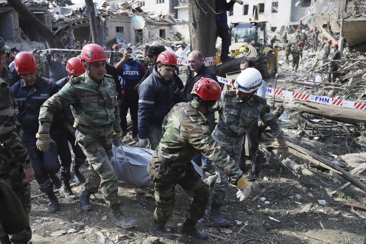 Dalam foto bertanggal 11 Oktober 2020 ini, tim penyelamat mengangkat korban luka ke ambulans setelah serangan dari artileri Armenia di kota Ganja, Azerbaijan. Perang dua negara di Nagorno-Karabakh selama dua pekan terakhir kini sudah menewaskan 600 orang.