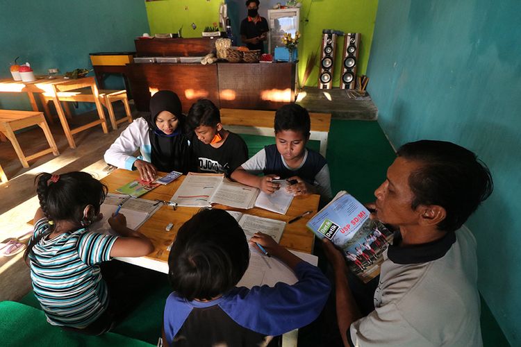 Pelajar bersama orang tuanya memanfaatkan internet gratis untuk belajar di warung makan di Desa Mlati, Kediri, Jawa Timur, Senin (27/7/2020). Pemilik warung menyediakan internat gratis bagi pelajar untuk menunjang pembelajaran jarak jauh saat pandemi COVID-19 tanpa harus memesan makanan atau minuman guna meringankan beban orang tua membeli paket internet.