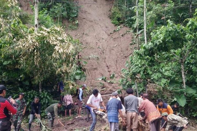 Warga dan aparat membersihkan materiil tanah longsor yang menutup jalan di Dusun Krajan, Desa Tileng, Kecamatan Dagangan, Kabupaten Madiun, Sabtu ( 25/2/2017). 