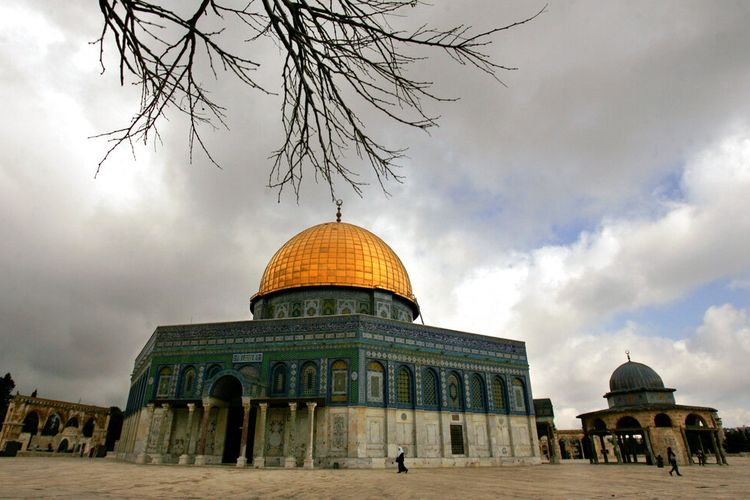 Jamaah Muslim Palestina berjalan di sebelah Masjid Kubah Emas Batu, di dalam kompleks Masjid Al Aqsa di kota tua Yerusalem, Senin, 2 April 2007. 