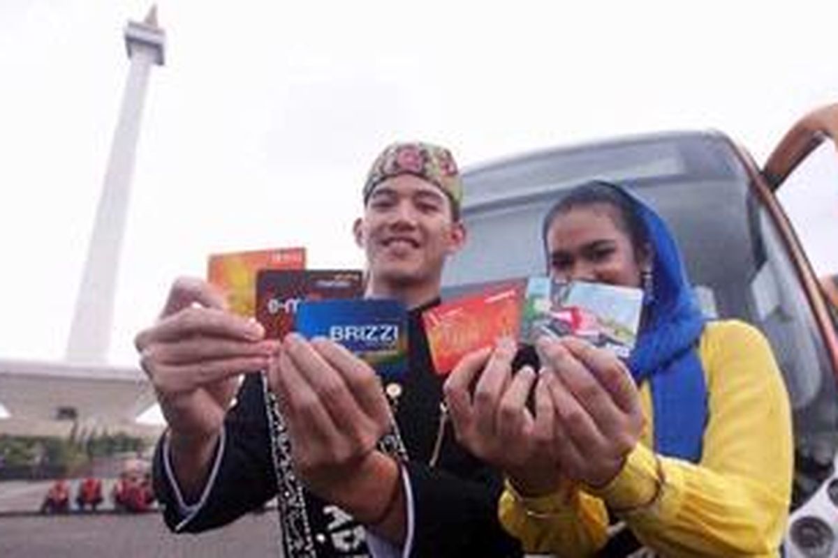 Abang-Nona Jakarta memperlihatkan kartu e-ticketing Transjakarta dari lima bank saat peluncurannya di Monumen Nasional, Jakarta Pusat, Selasa (22/1/2013). Pemerintah Provinsi DKI Jakarta mengajak PT. Bank Negara Indonesia (Persero) Tbk, PT. Bank Mandiri (Persero) Tbk, PT. Bank Rakyat Indonesia (Persero) Tbk, PT. Bank DKI serta PT. Bank Central Asia Tbk untuk melayani penumpang Transjakarta. Nantinya produk e-money dari kelima bank konsorsium tersebut diharapkan akan terintegrasi pemakaiannya untuk Kopaja, Metromini, dan kereta api.

