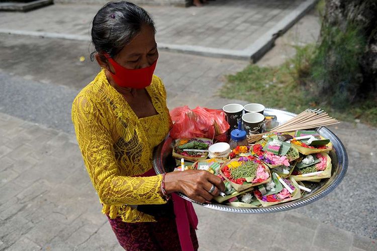 Warga membawa sejumlah sesaji saat perayaan Hari Raya Kuningan di Pura Sakenan di Pulau Serangan, Bali, Sabtu (26/9/2020). Hari Raya Kuningan yang digelar beberapa hari setelah Galungan ini dimaksudkan untuk merayakan saat Dewa-dewa dan leluhur kembali ke surga setelah bertemu keturunannya.