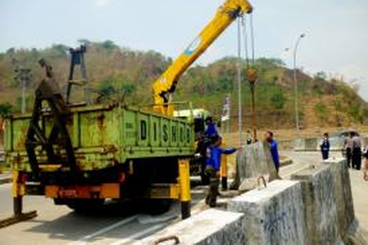 Sejumlah petugas Dishubkominfo dengan menggunakan derek tengah memindahkan barier beton yang menutup akses tol Sidomulyo-Kalirejo, Jumat (30/10/2015) siang