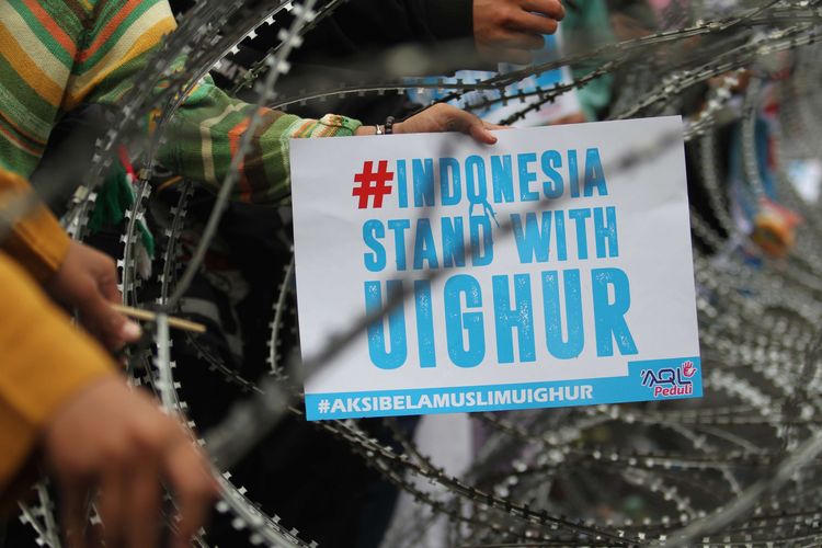 Massa aksi mengangkat spanduk saat demonstrasi terkait kasus penindasan etnis Uighur di depan Kantor Kedutaan Besar (Kedubes) China, Kuningan, Jakarta Selatan, Jumat (27/12/2019). Mereka membawa spanduk-spanduk berisi desakan terhadap pemerintah China.
