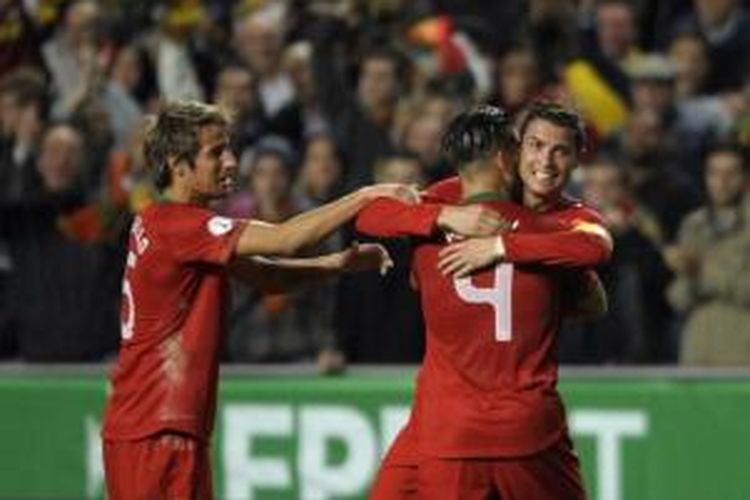 Kapten Portugal, Cristiano Ronaldo, merayakan gol yang dicetaknya ke gawang Swedia bersama dua rekan setim, Fabio Coentrao dan Miguel Veloso. Pada laga leg pertama play-off Piala Dunia 2014 di Stadion da Luz, Lisabon, Portugal berhasil menang 1-0 atas Swedia.