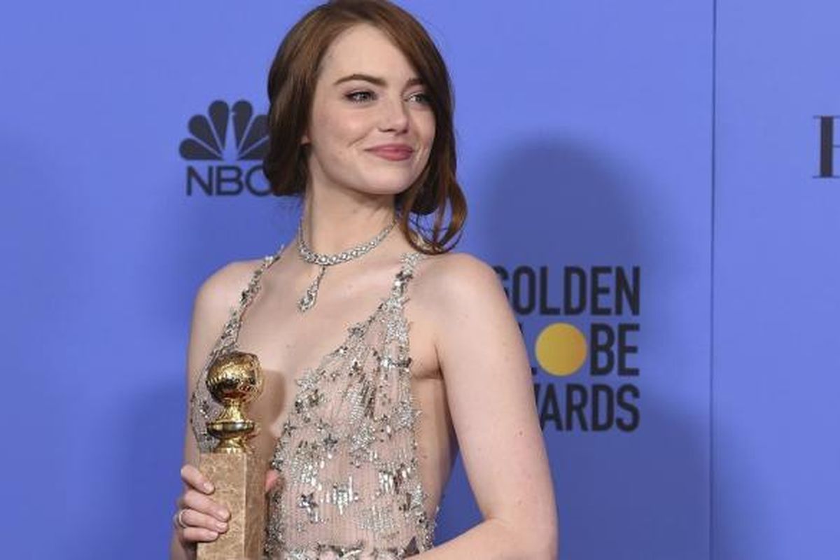 Aktris Emma Stone berpose bersama trofi aktris terbaik untuk film musikal/komedi pada ajang Golden Globe Awards 2017 yang digelar di Beverly Hills, California, Minggu (8/1/2017).