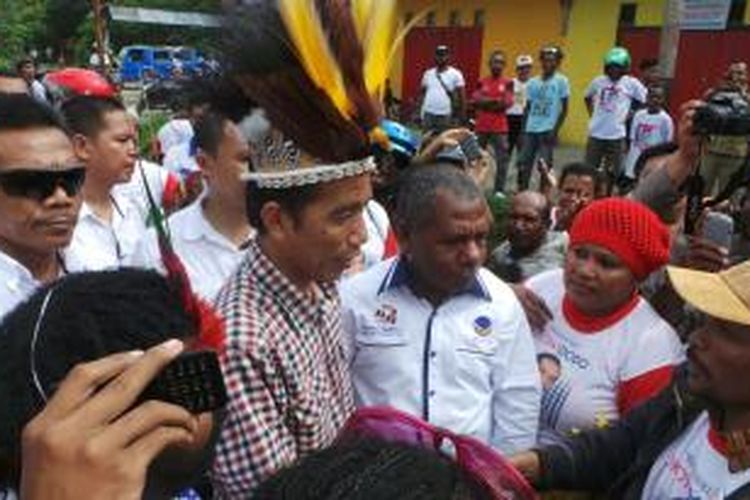 Calon presiden Joko Widodo diberikan topi kebesaran raja oleh pemuda pendukungnya di Jalan Holheta, Harapan, Jayapura, Kamis  (5/6/2014). 
