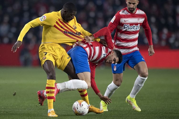 Penyerang Barcelona Ousmane Dembele (kiri) berduel dengan bek Granada Carlos Neva dalam laga lanjutan Liga Spanyol musim 2021-2022 di Stadion Los Carmenes pada Minggu (9/1/2022) dini hari WIB.