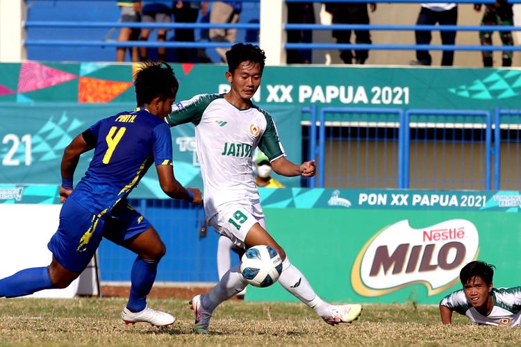 Pemain Jawa Timur Malik Prayitno dijaga pemain Jawa Barat saat babak 6 besar PON XX Papua 2021 yang berakhir dengan skor 0-2 di Stadion Barnabas Youwe Sentani Kabupaten Jayapura, Minggu (10/10/2021) sore.