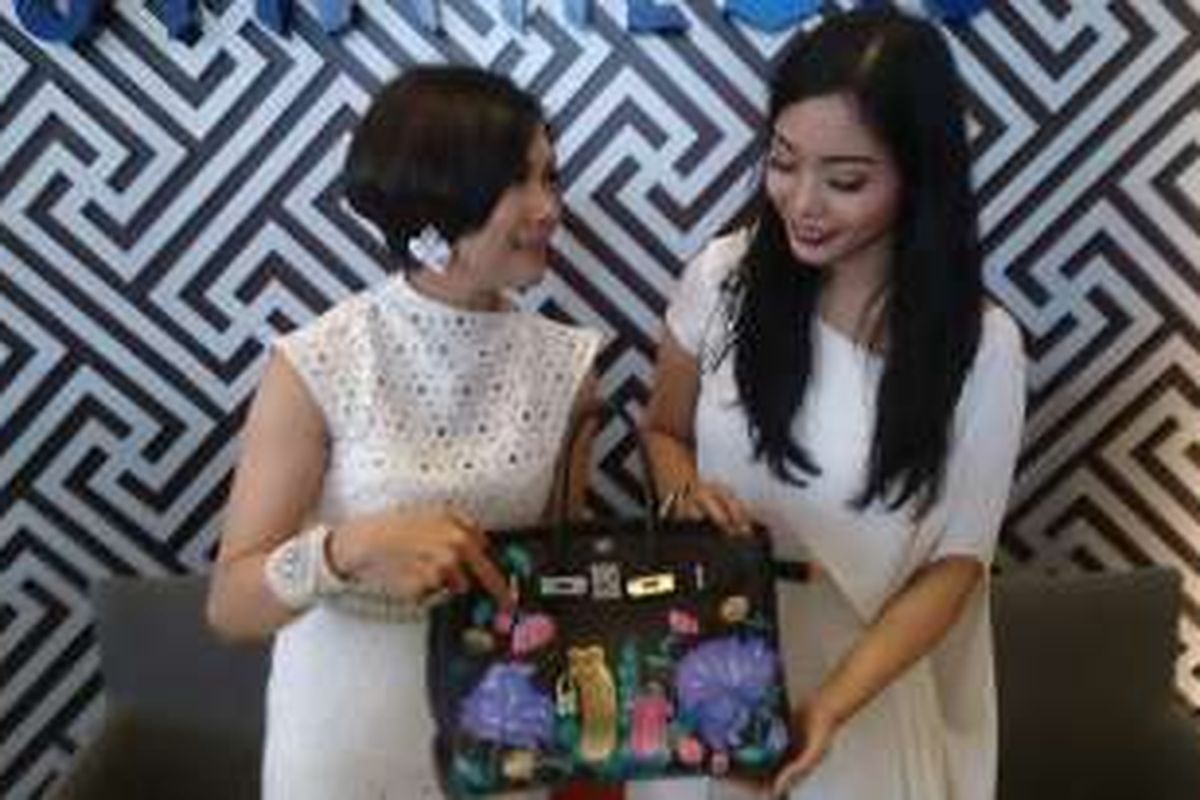 Yulie Nasution Grillon dan Dara Setyohadi memegang karya tas Hermes Birkin yang dilukisnya