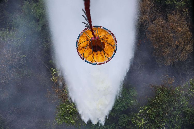 Pekerja melepaskan water bombing ke titik api yang terbakar di Kawasan hutan di Palangka Raya, Kalimantan Tengah, Senin (30/9/2019).