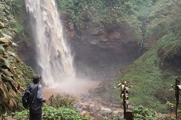 Wisatawan menyaksikan Air Terjun Cipendok, Cilongok Banyumas, Jateng dari kejauhan. Dedaunan pohon dan tumbuhan hijau di sekitar air terjun berubah coklat dan kotor karena terkena percikan air terjun yang keruh bercampur lumpur. 