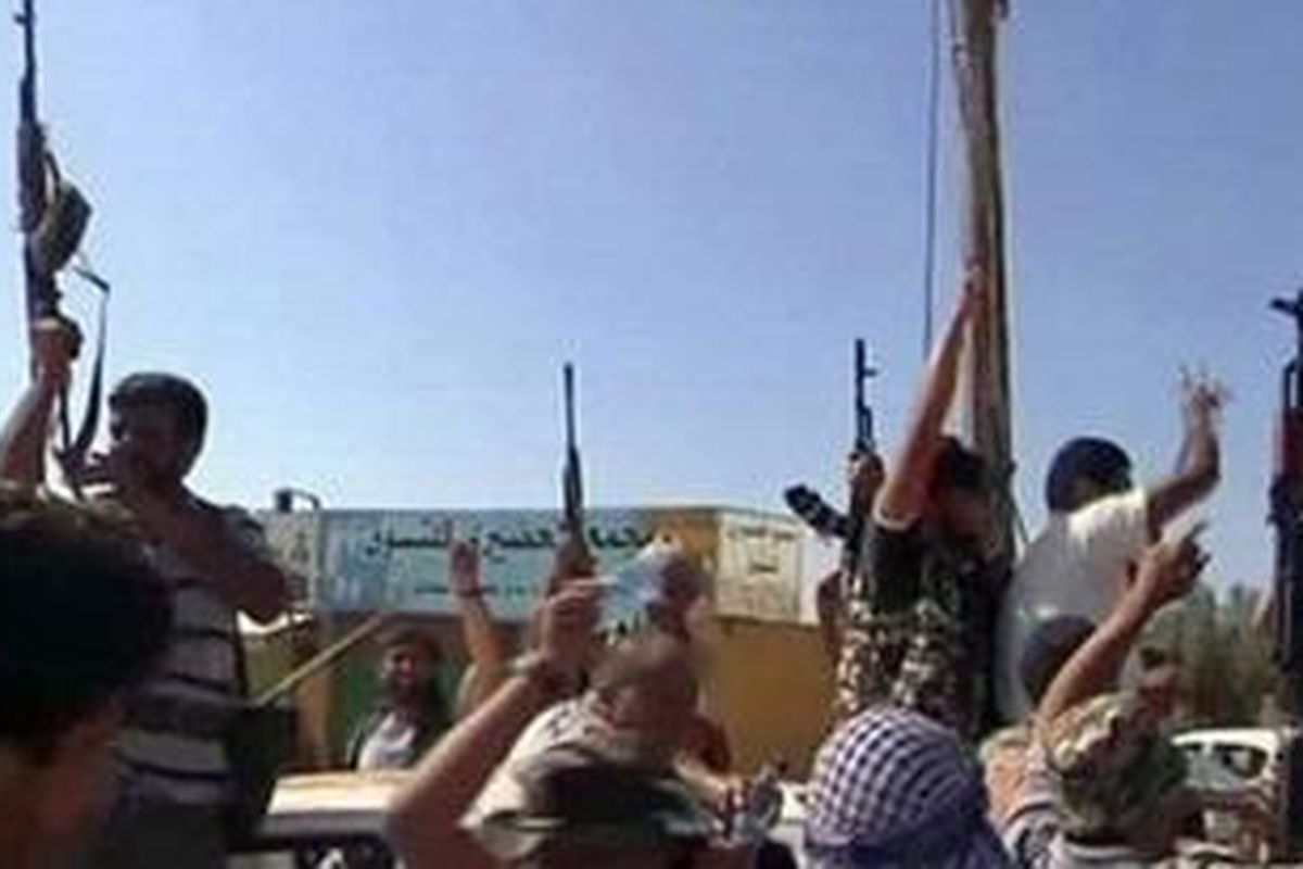 Pemberontak Libya merayakan kemenangan setelah berhasil merebut sebuah kota markas pasukan elit Brigade ke-32 yang dipimpin oleh putra Moammar Kadhafi,  Khamis, 16 mil barat Tripoli, 21 Agustus 2011