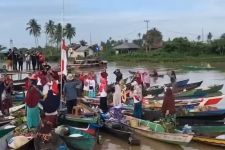 Acil-acil Pasar Terapung Lok Baintan di Kabupaten Banjar, Kalsel turut menggelar upacara bendera di Sungai Martapura menggunakan Jukung, Rabu (17/8/2022). 