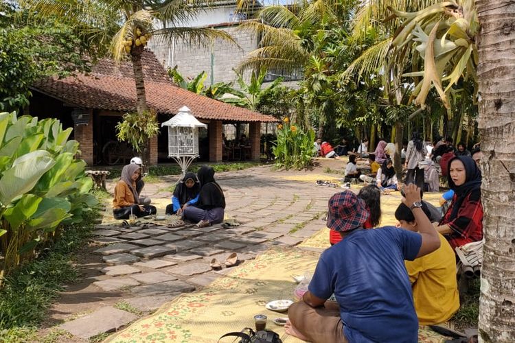 Para pengunjung duduk lesehan di tepi sawah Warung Kopi Klotok, Sleman Yogyakarta, Rabu (22/1/2020). Pengunjung bisa duduk di dalam rumah joglo maupun di luar dengan cara lesehan tikar.